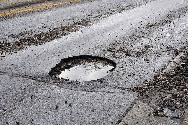 Large pothole as shown causes bent rims and damaged tires.